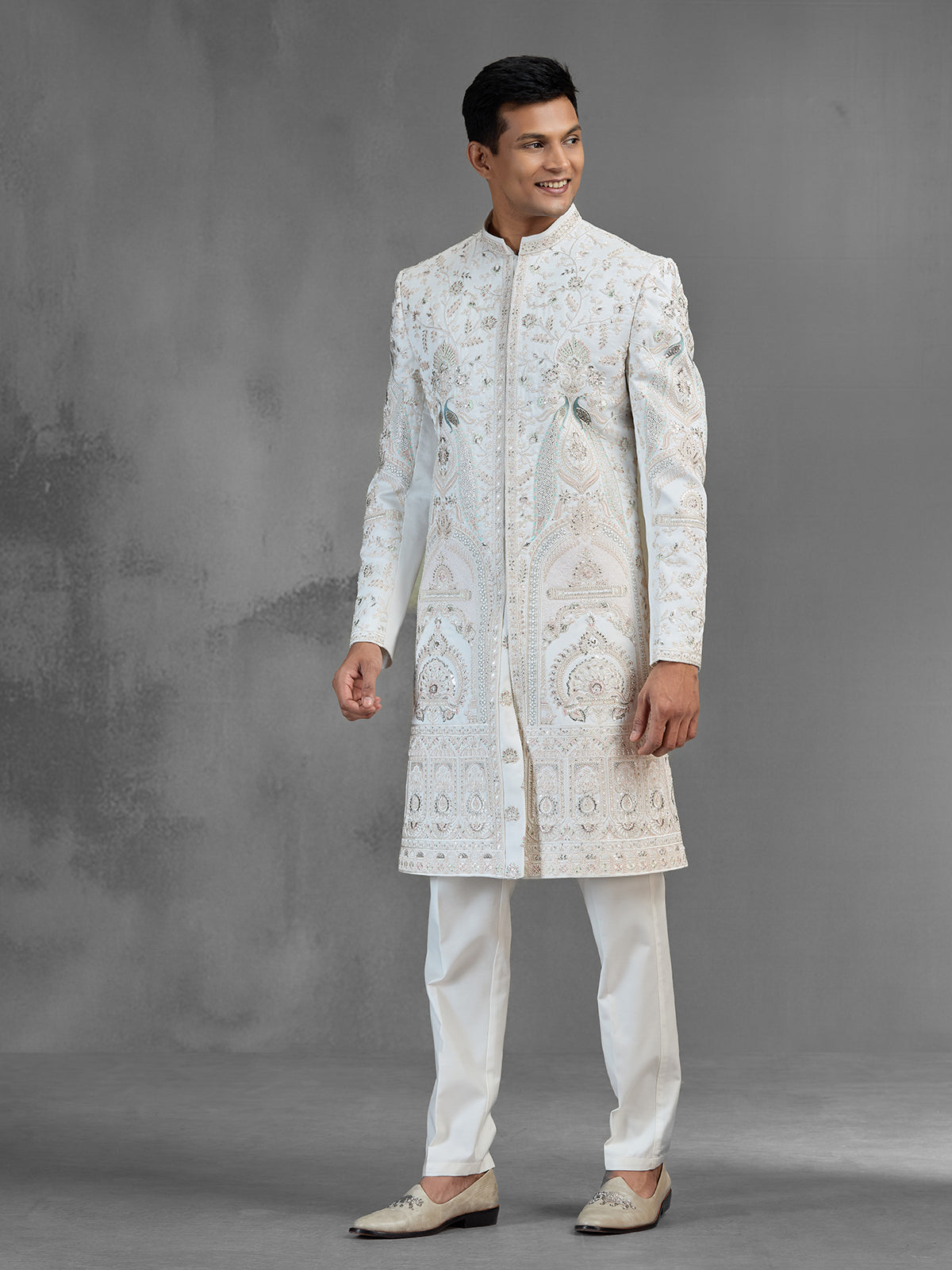 Cream silk sherwani with aqua peacock thread work design