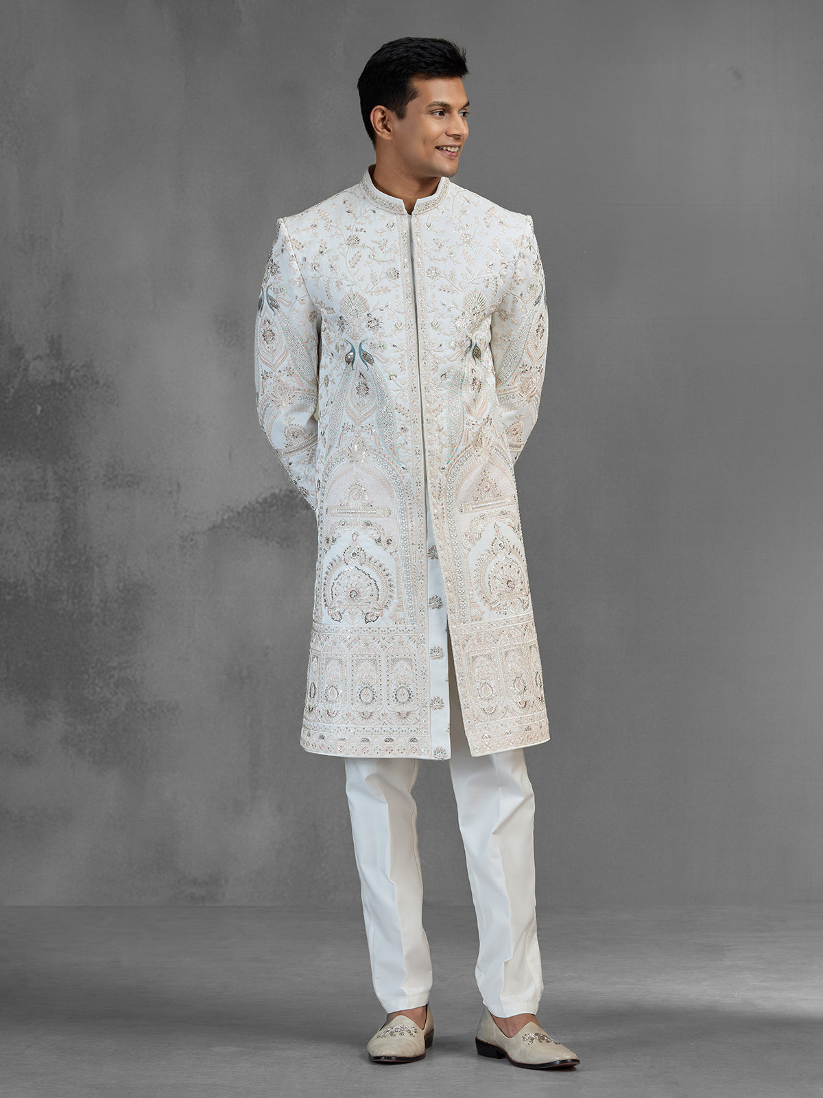 Cream silk sherwani with aqua peacock thread work design