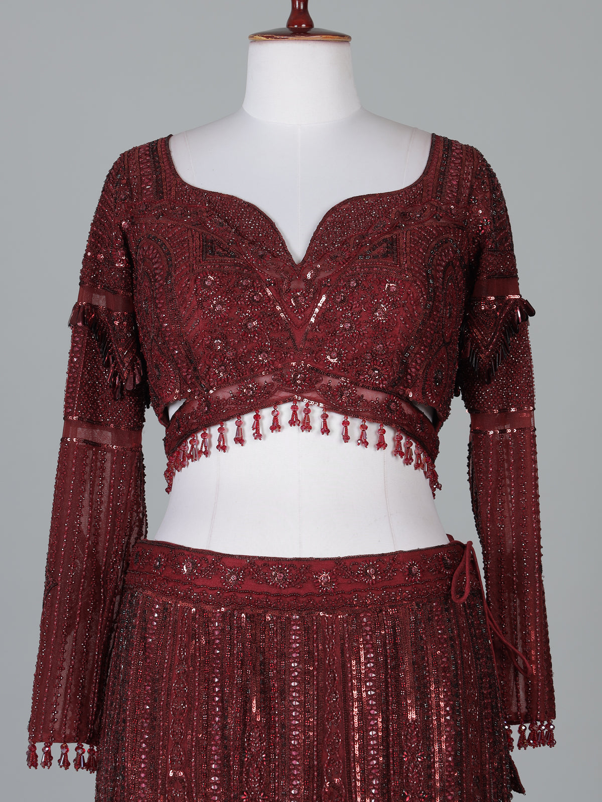 Maroon net lehenga choli with intricate handwork
