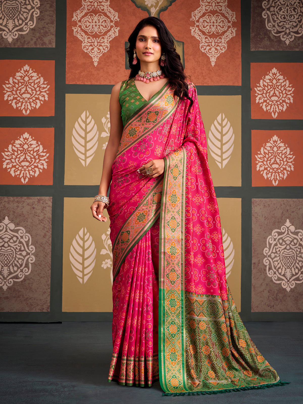 Vibrant pink bandhani inspired patola silk saree with contrast green blouse