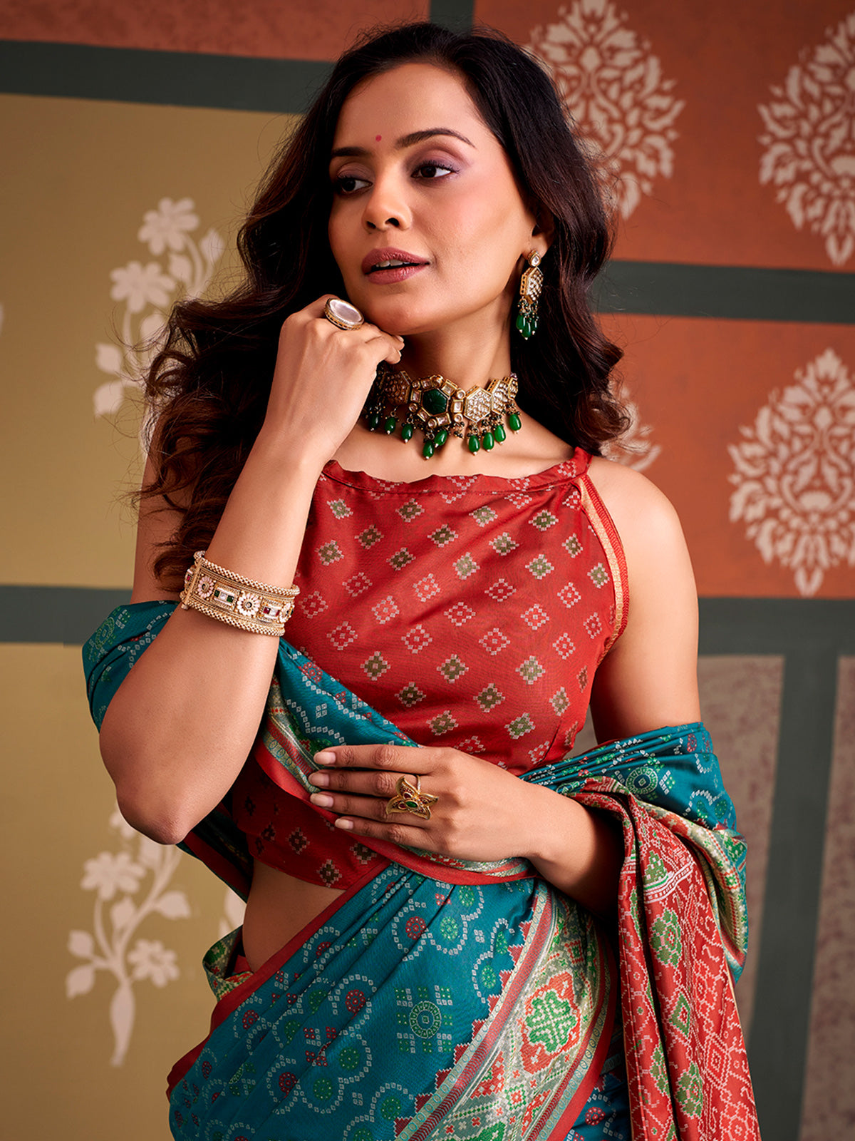 Opulent teal blue zari woven patola silk saree with contrast red blouse
