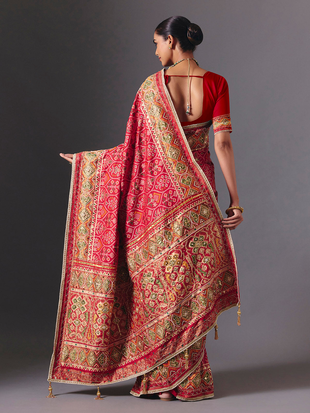 Rani pink art silk patola saree with festive handcrafted embellishments