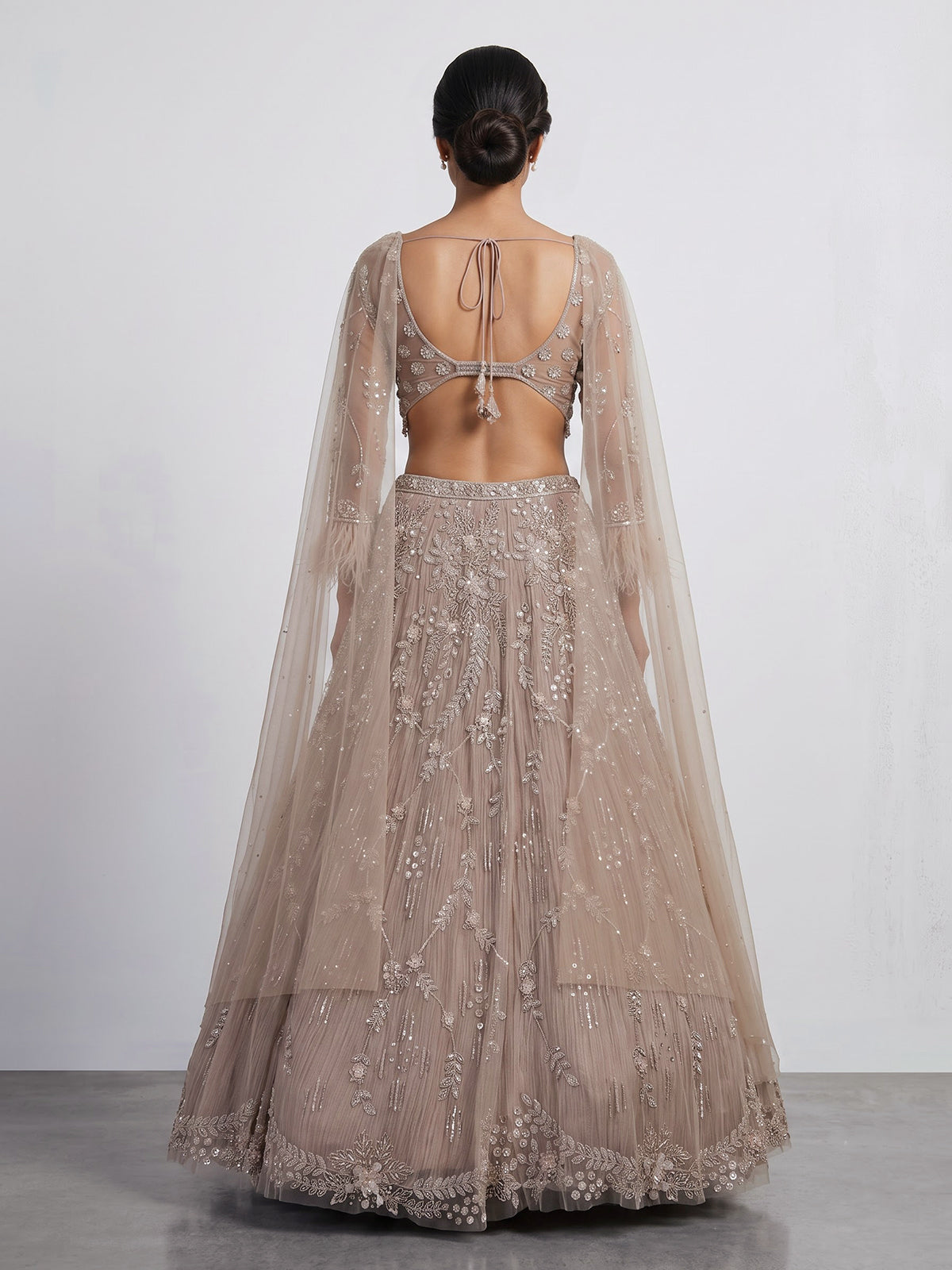 Beige net lehenga choli with pearls diamonds and tassel detailing