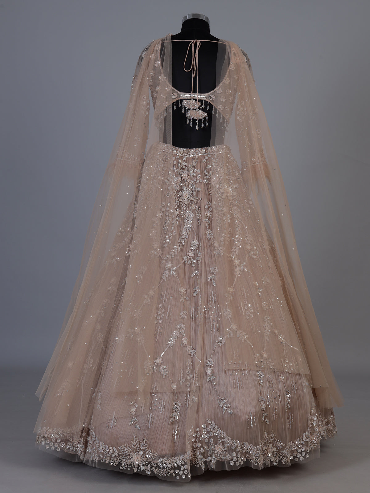 Beige net lehenga choli with pearls diamonds and tassel detailing