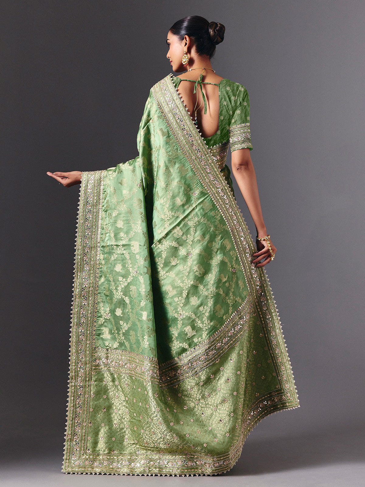 Pista green satin silk saree with ornate animal motif detailing
