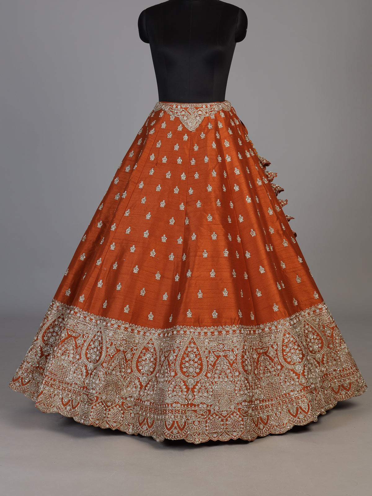 Rust orange raw silk unstitched lehenga choli with ornate butti detailing