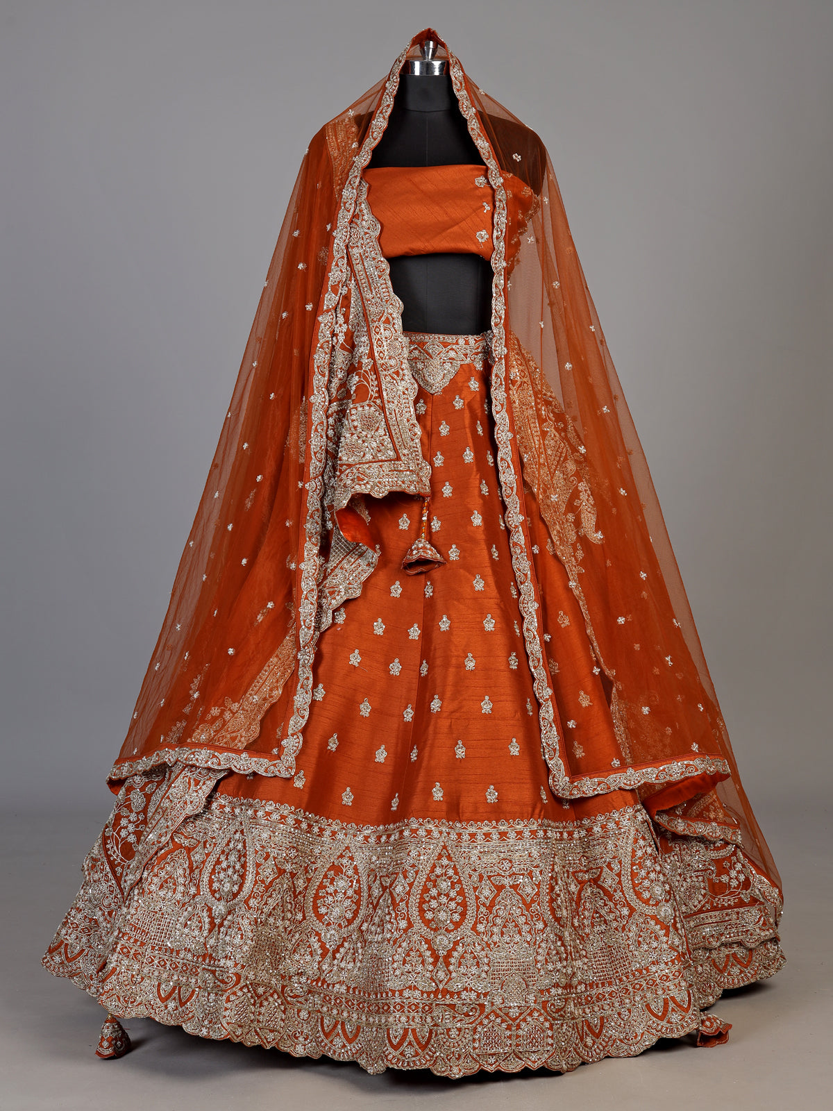 Rust orange raw silk unstitched lehenga choli with ornate butti detailing