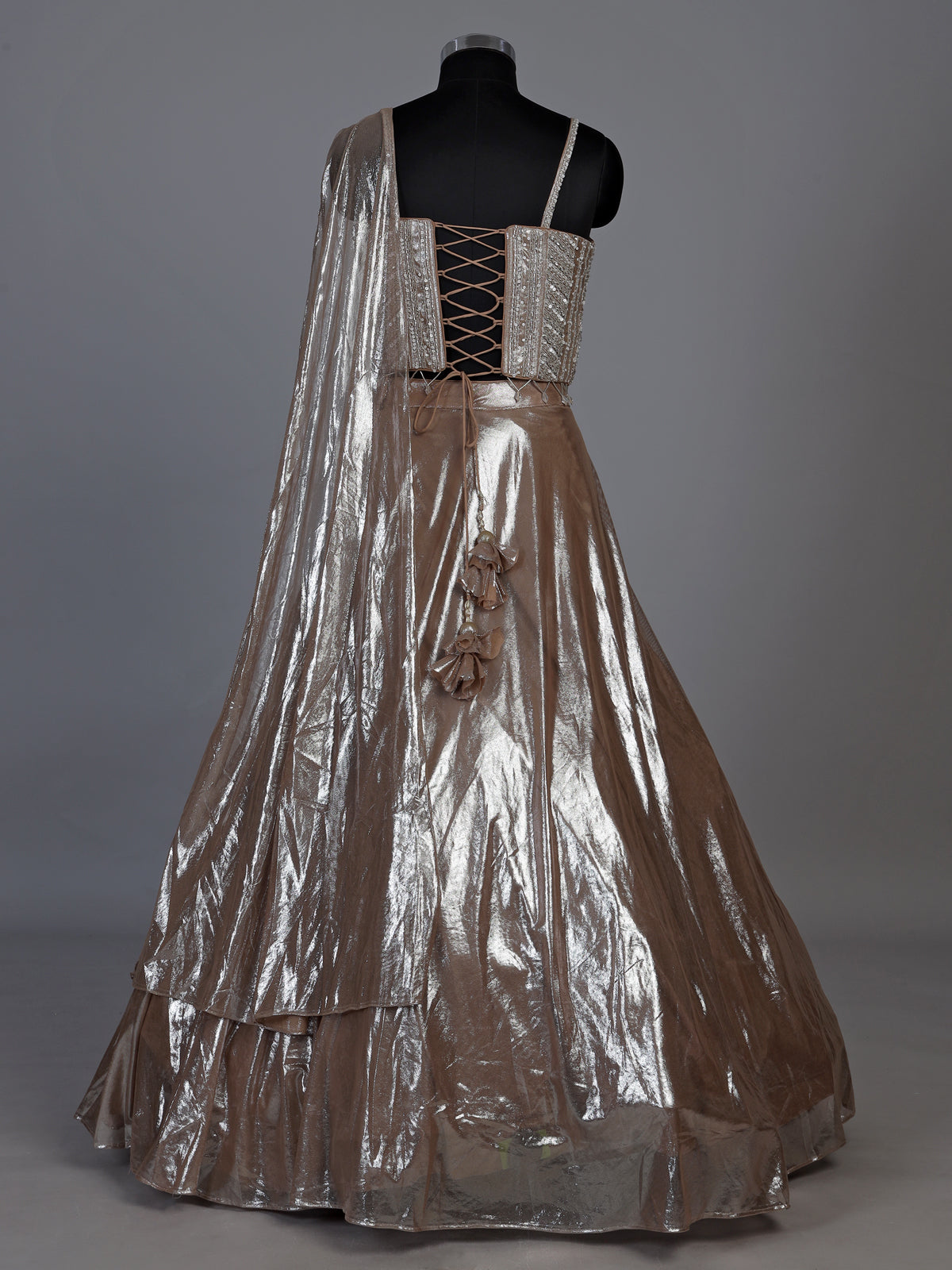 Sophisticated beige shimmer tissue silk lehenga choli with tassel accents