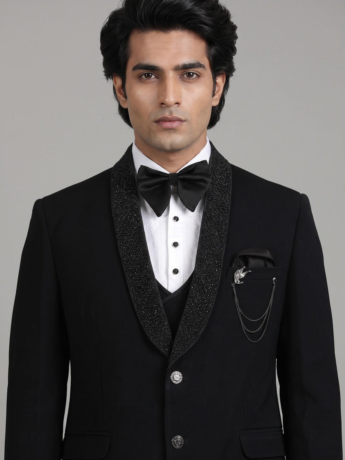 Jet black three-piece tuxedo suit with crystal brooch and cutdana