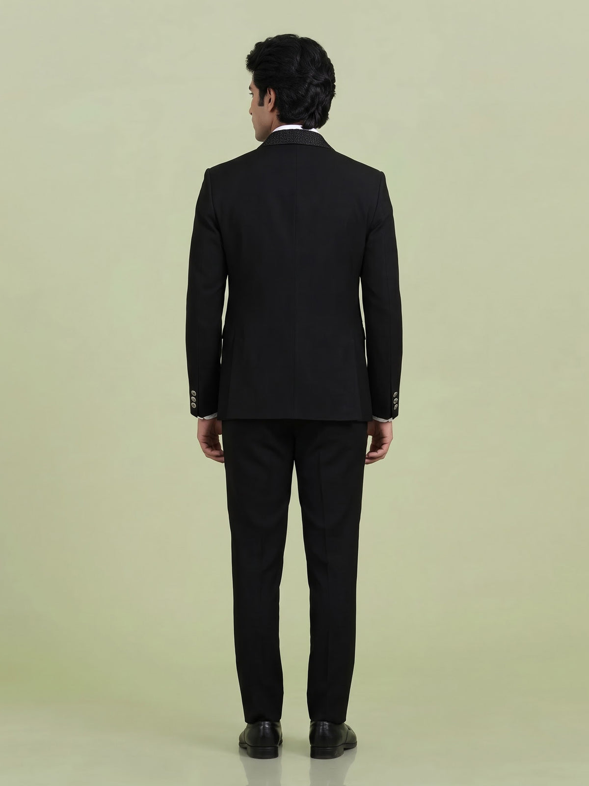 Jet black three-piece tuxedo suit with crystal brooch and cutdana