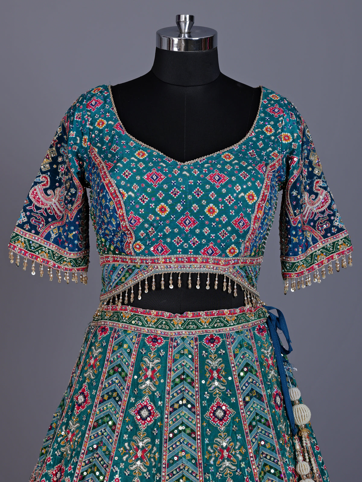 Rama green silk lehenga choli with bandhani patola detailing