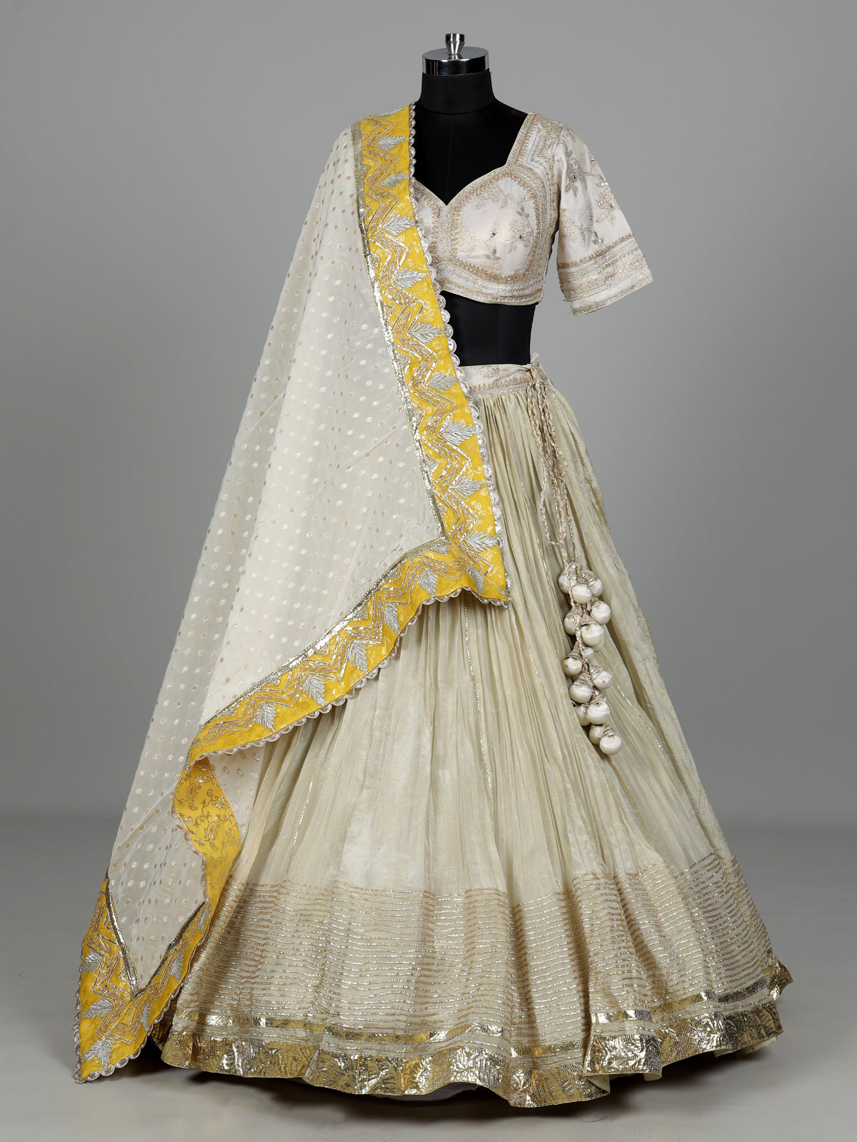 Beige silk lehenga choli with traditional aabla and gota work