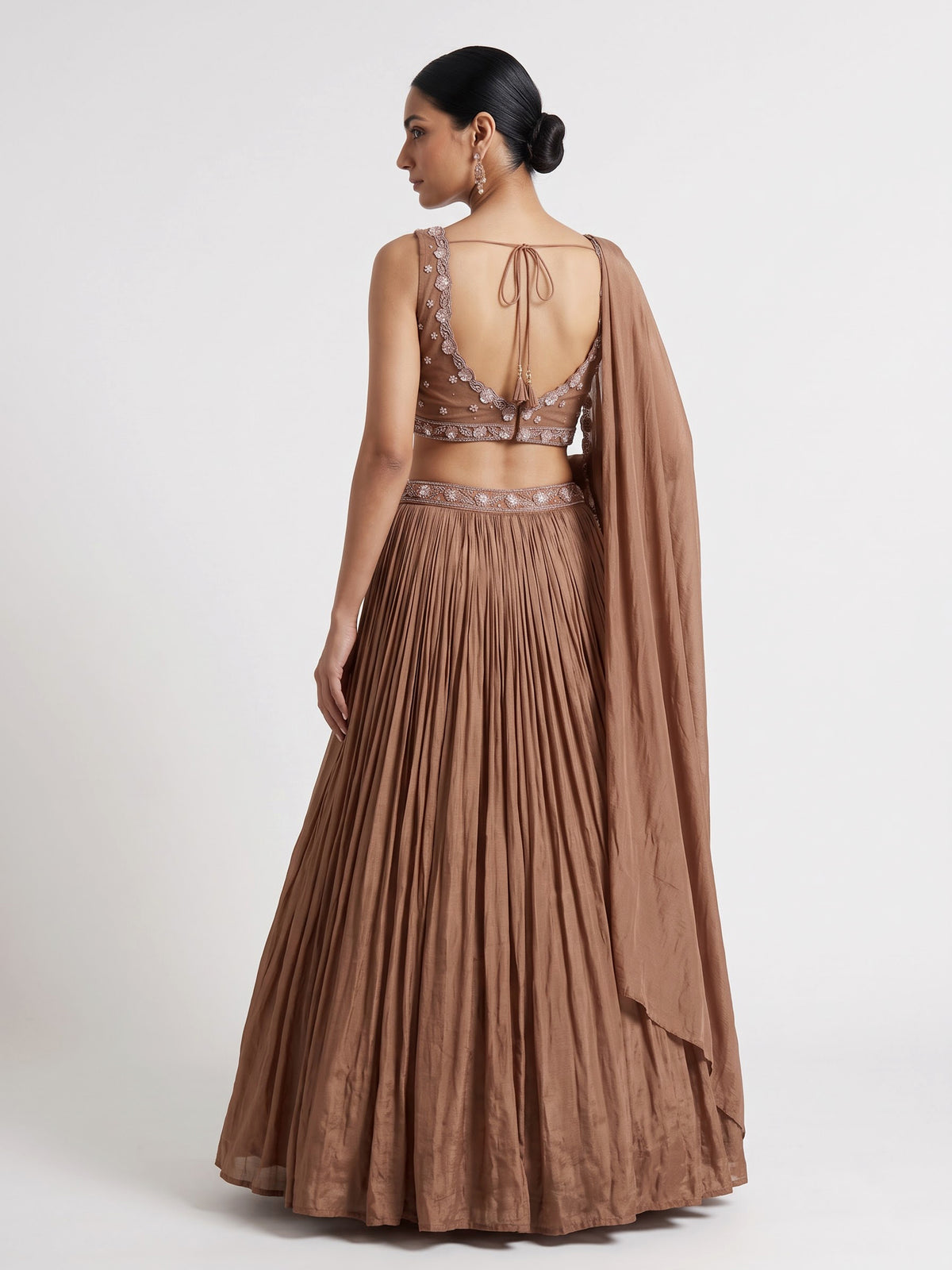 Beige chiffon silk lehenga choli with diamond and tassel accents