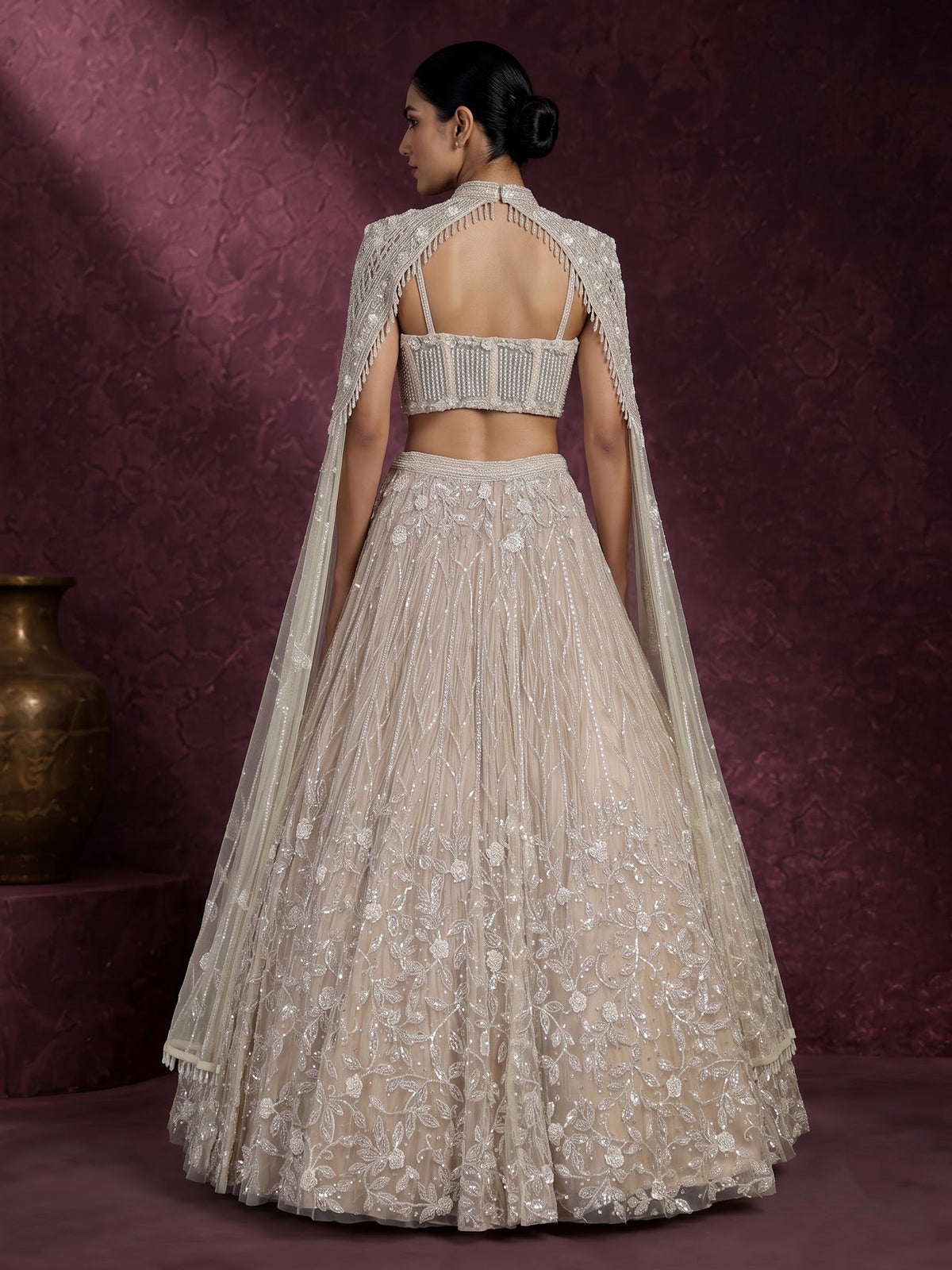 Beige net designer lehenga choli with heavy embellished cape shrug