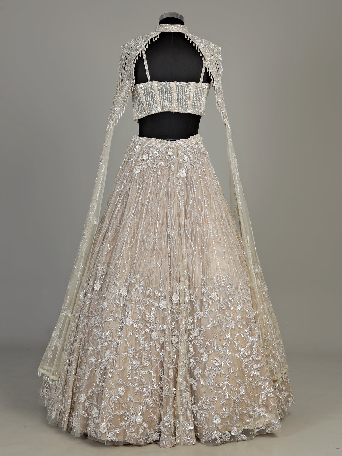 Beige net designer lehenga choli with heavy embellished cape shrug