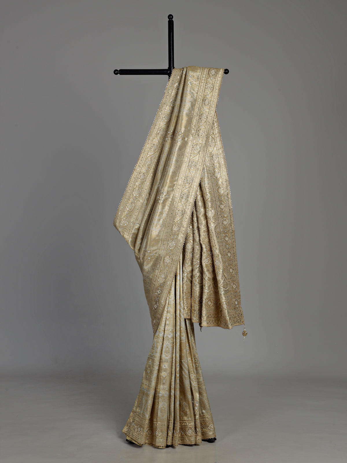 Pastel cream tissue silk saree with intricate festive embellishments and zari