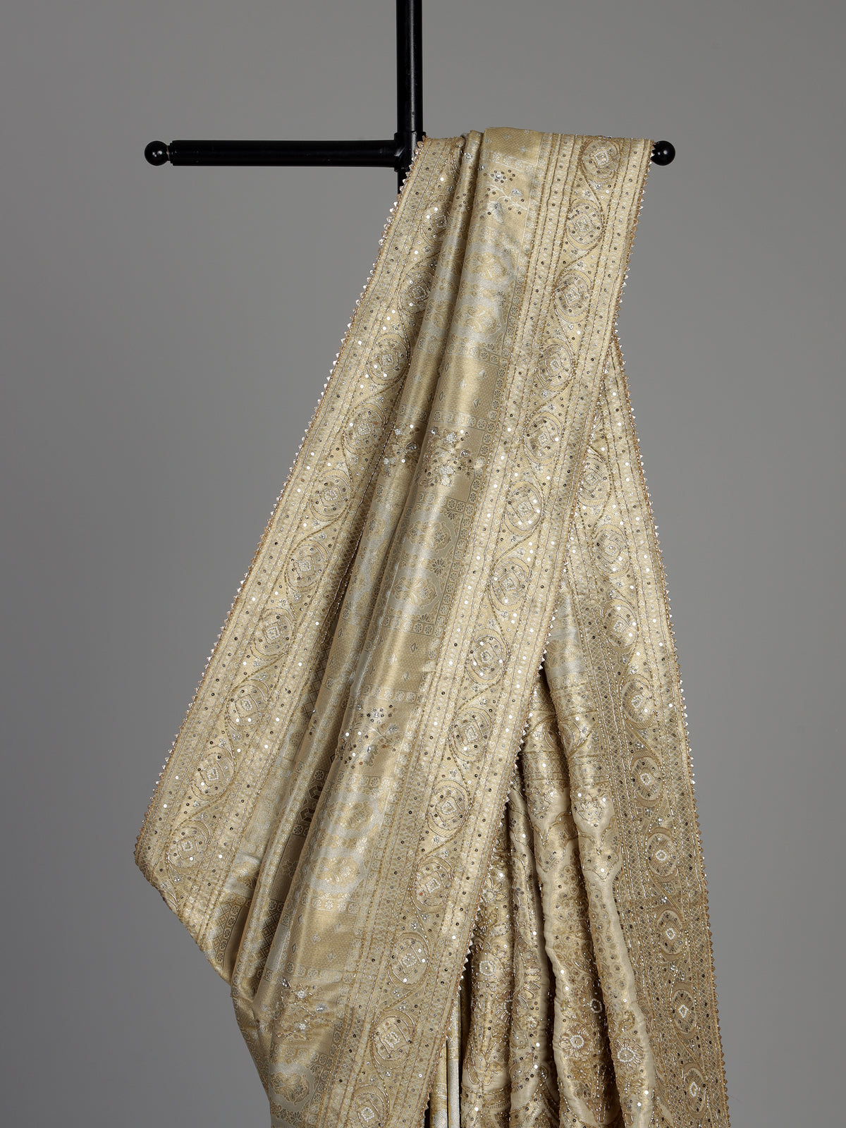 Pastel cream tissue silk saree with intricate festive embellishments and zari
