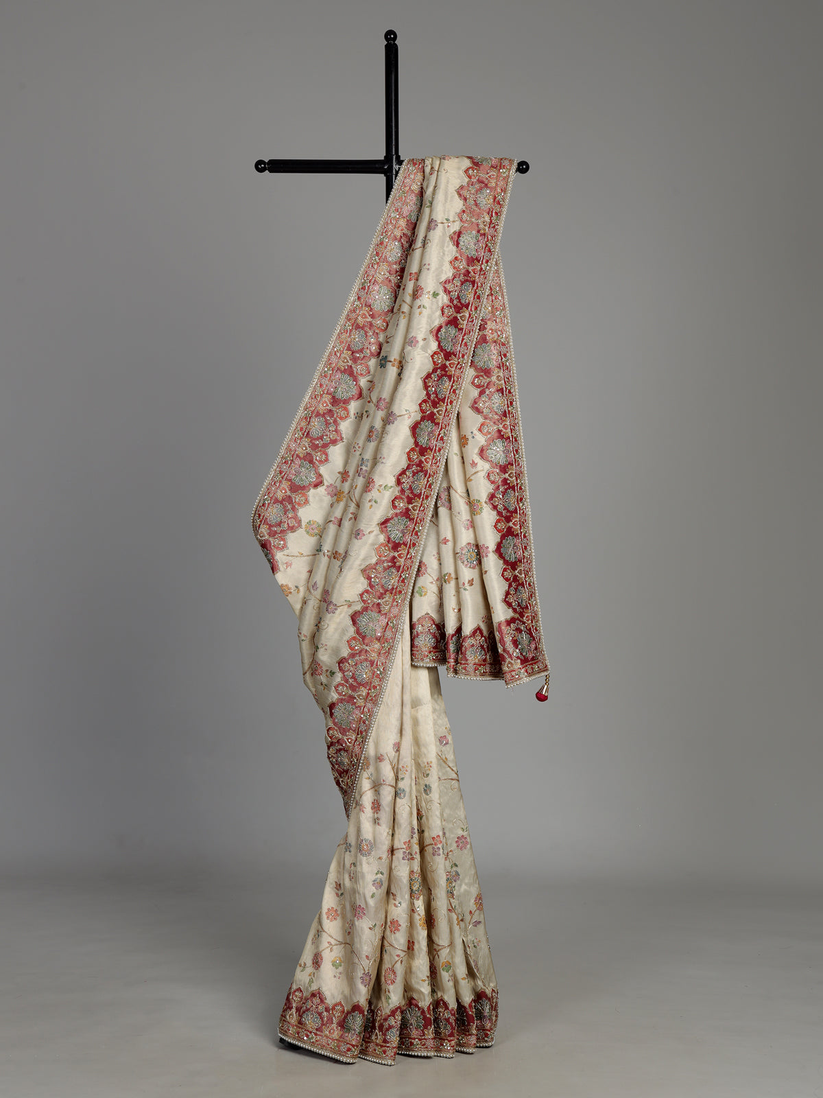 Cream pashmina saree with floral motifs and contrasting embellished border