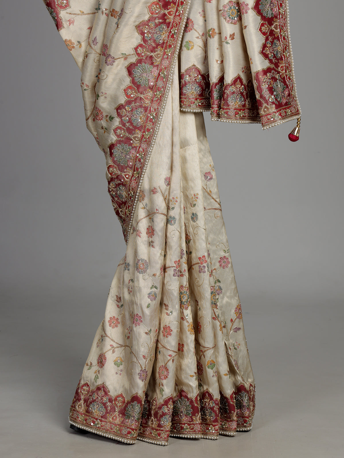 Cream pashmina saree with floral motifs and contrasting embellished border