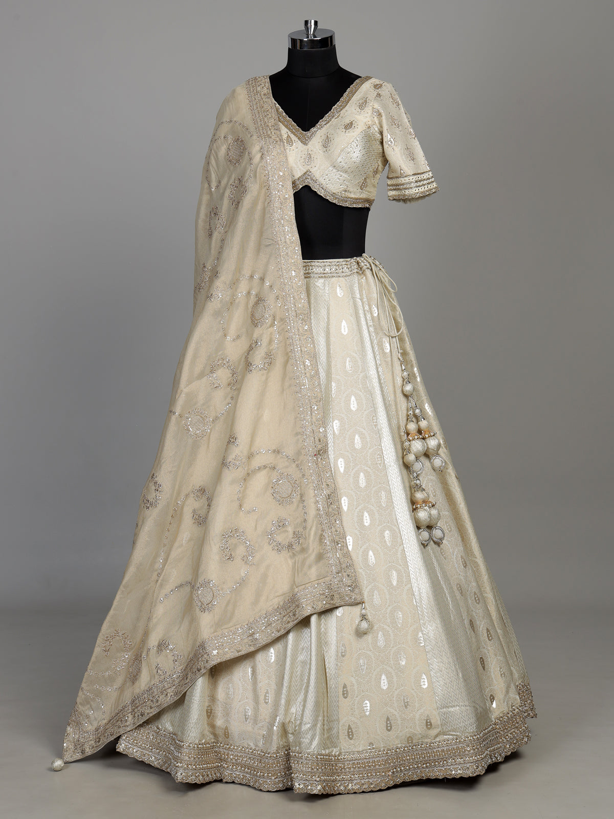 Cream banarasi silk lehenga choli with intricate zardosi embellishments