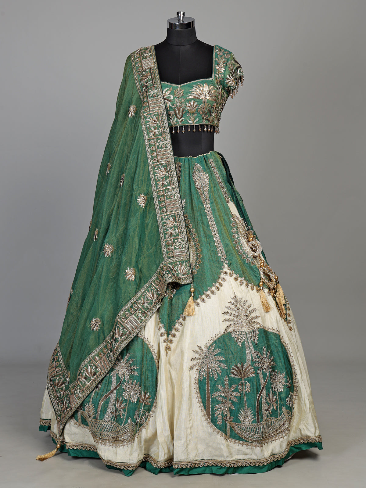 Green silk lehenga choli with intricate zardosi and tassel detailing