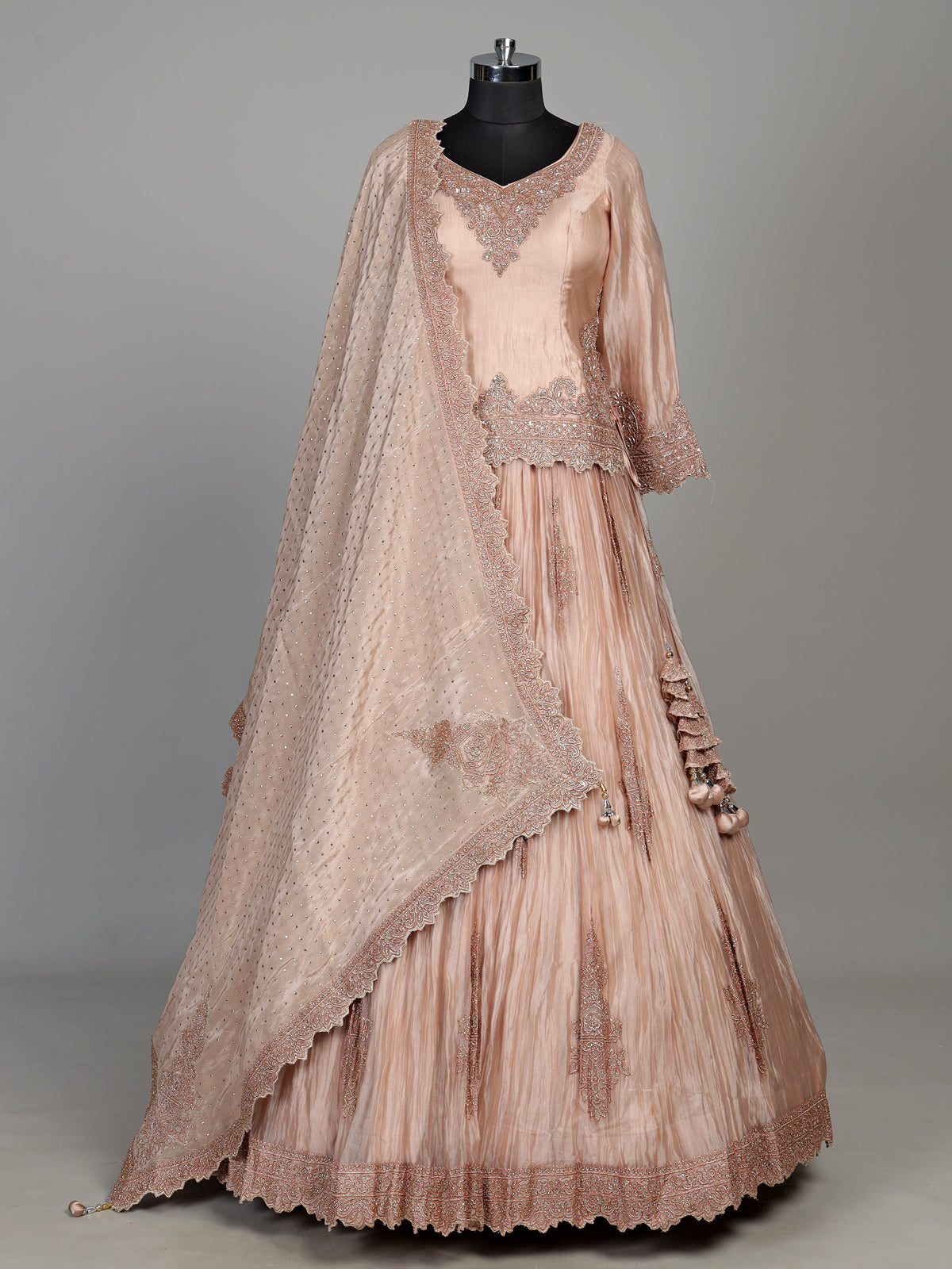 Pastel peach tissue silk lehenga choli with intricate cutdana embellishments
