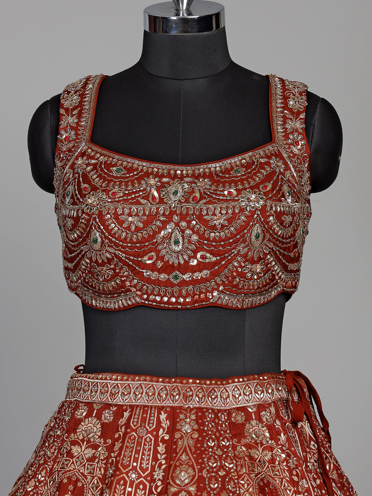 Rust orange silk lehenga choli with mirror and zardosi work