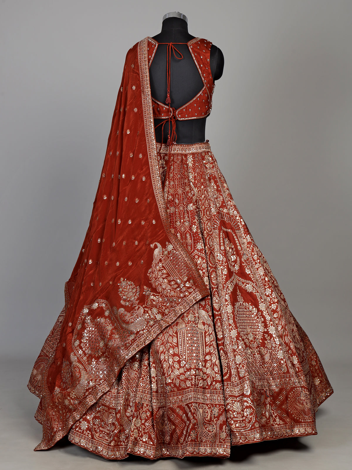 Rust orange silk lehenga choli with mirror and zardosi work