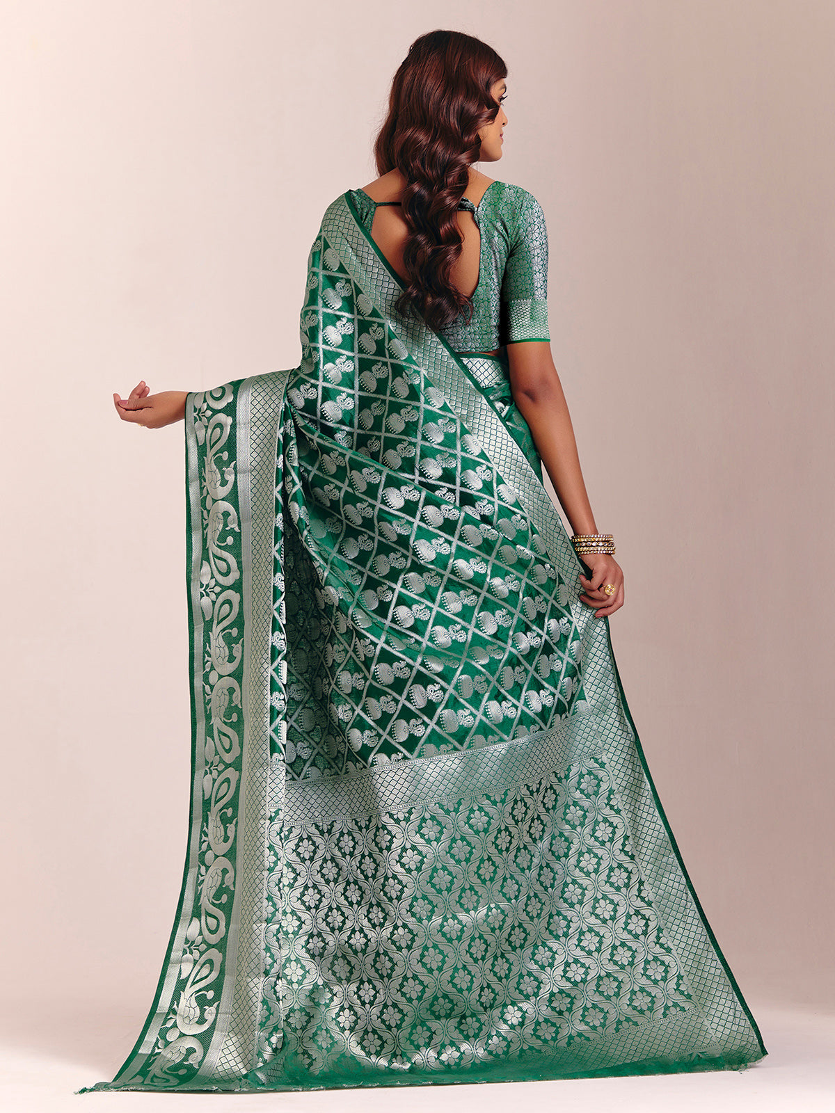 Green silk saree featuring traditional zari detailing