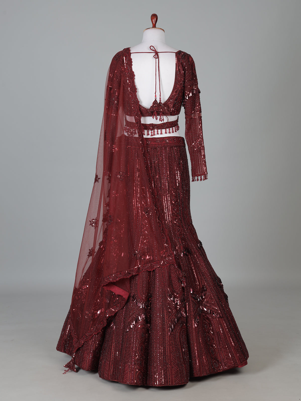 Maroon net lehenga choli with intricate handwork