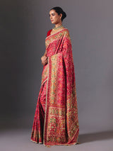 Rani pink art silk patola saree with festive handcrafted embellishments