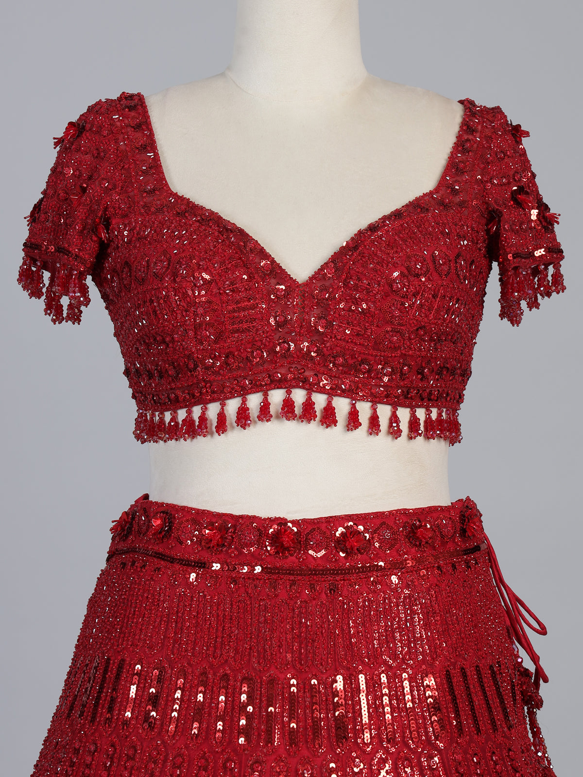 Maroon net designer lehenga choli with stone work tassel detailing