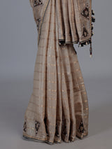 Pastel beige tusser silk saree with traditional handcrafted embellishments