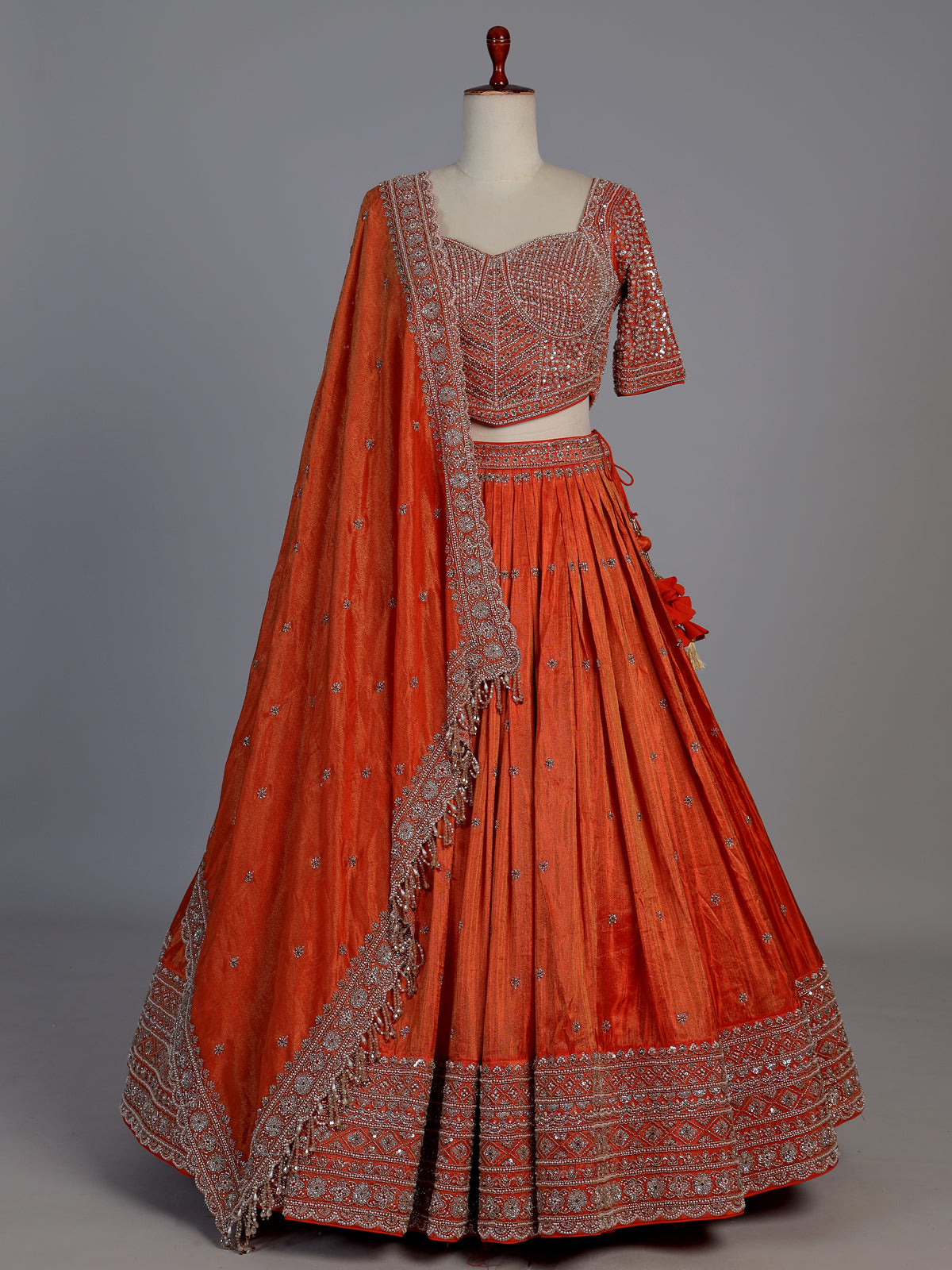 Rust orange silk embellished designer lehenga choli with tassel dupatta