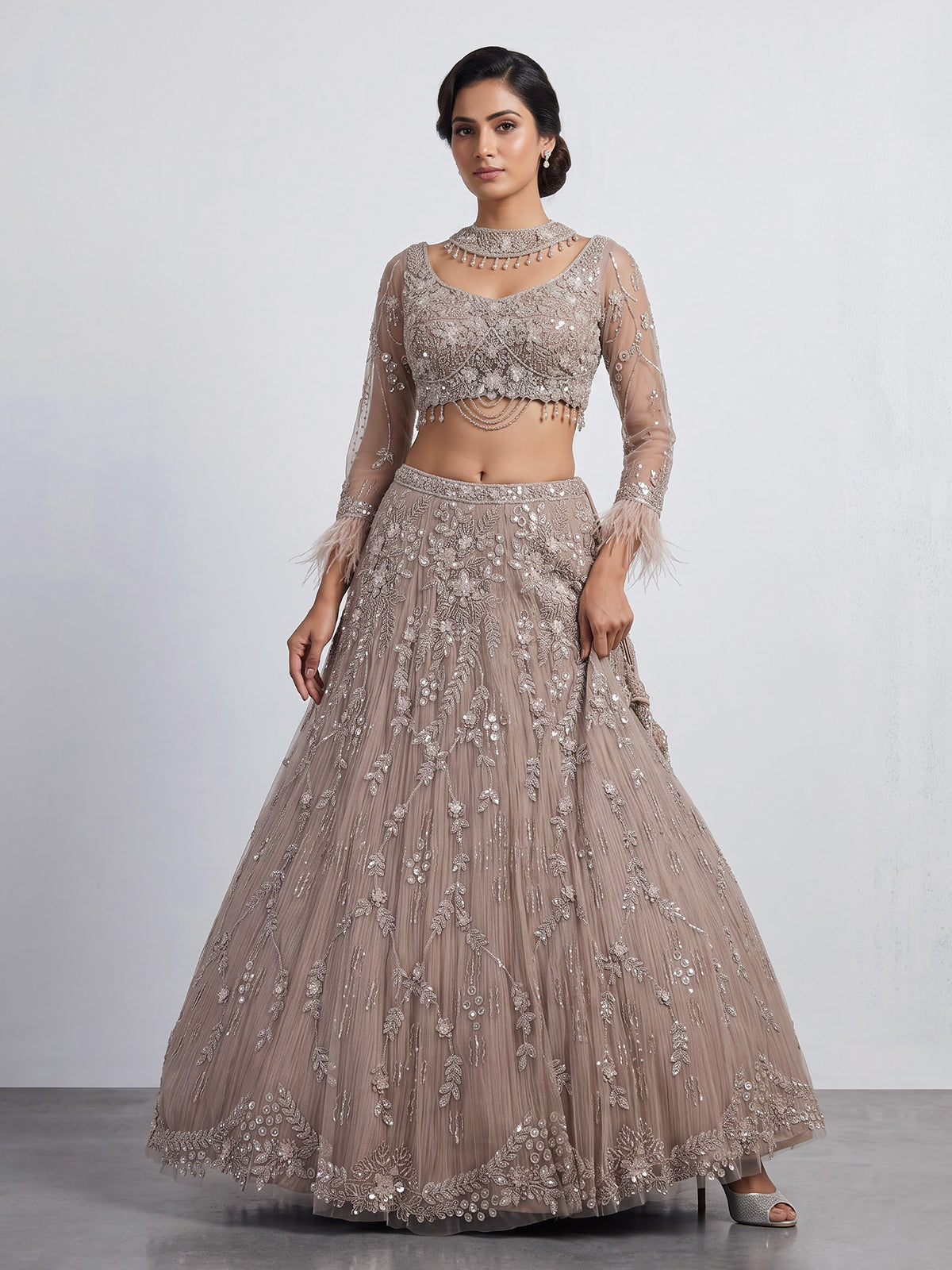 Beige net lehenga choli with pearls diamonds and tassel detailing