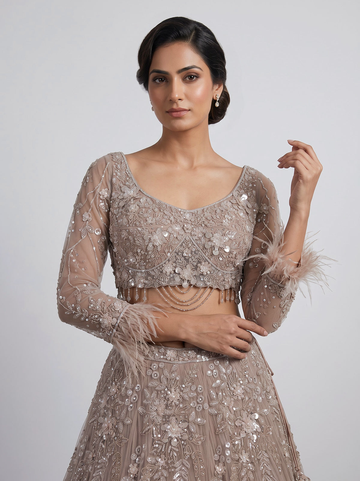 Beige net lehenga choli with pearls diamonds and tassel detailing