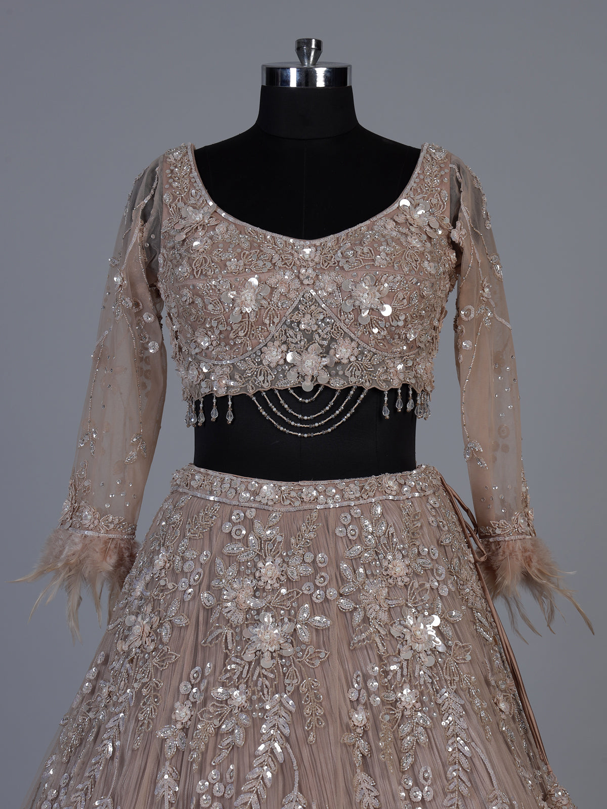 Beige net lehenga choli with pearls diamonds and tassel detailing