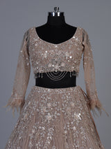 Beige net lehenga choli with pearls diamonds and tassel detailing