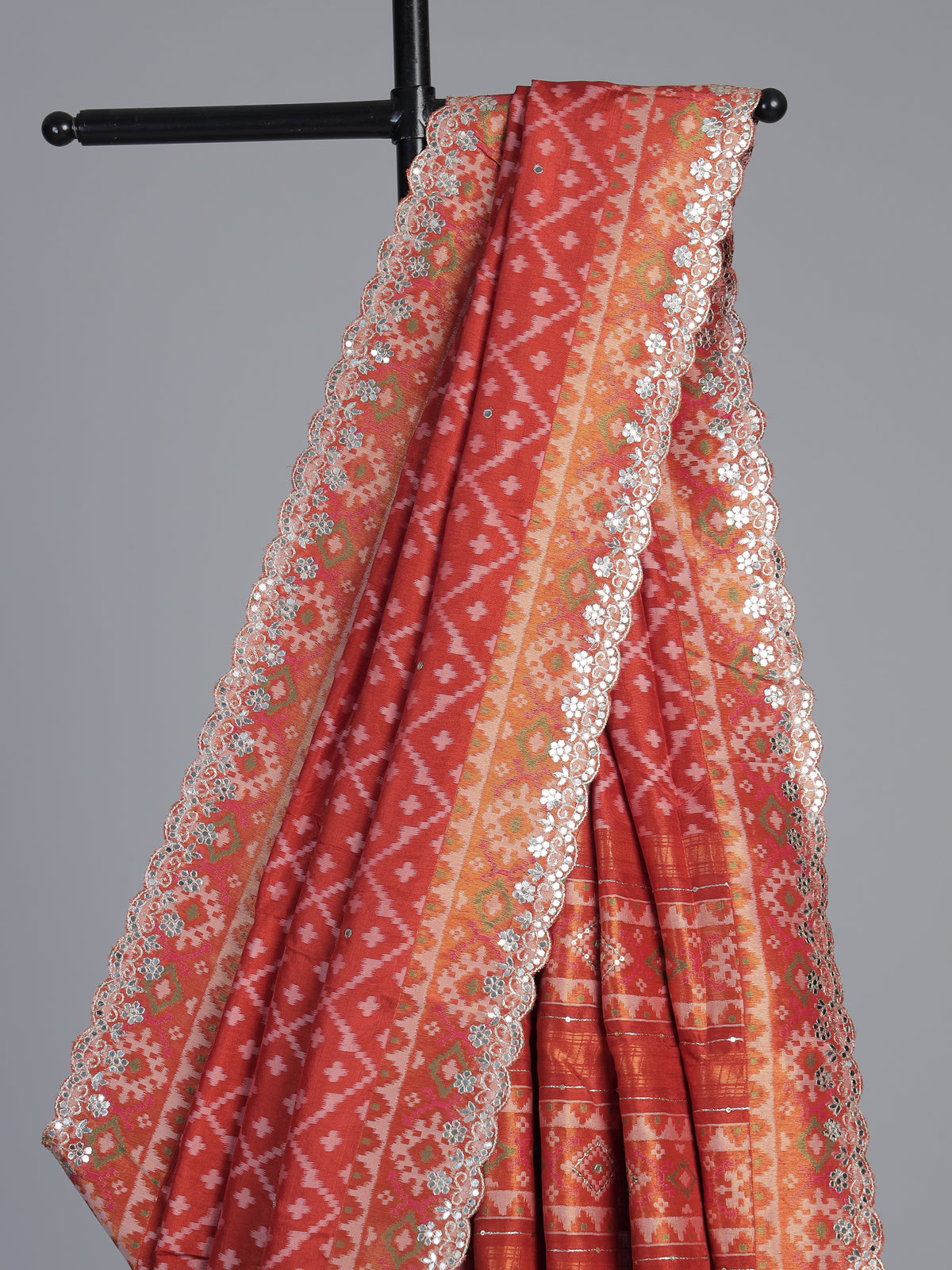 Rust orange soft silk saree with graceful ikat printed detailing