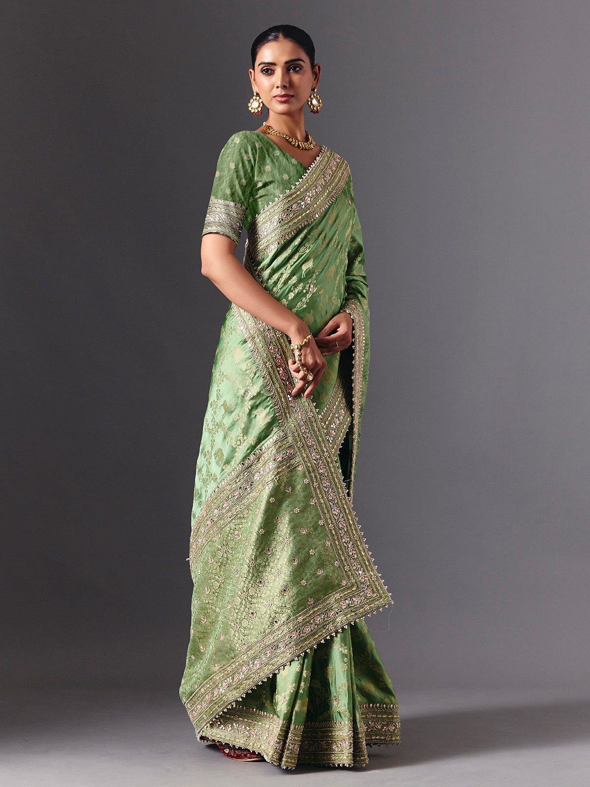 Pista green satin silk saree with ornate animal motif detailing