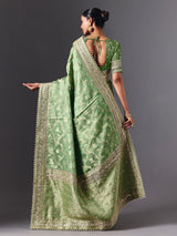 Pista green satin silk saree with ornate animal motif detailing