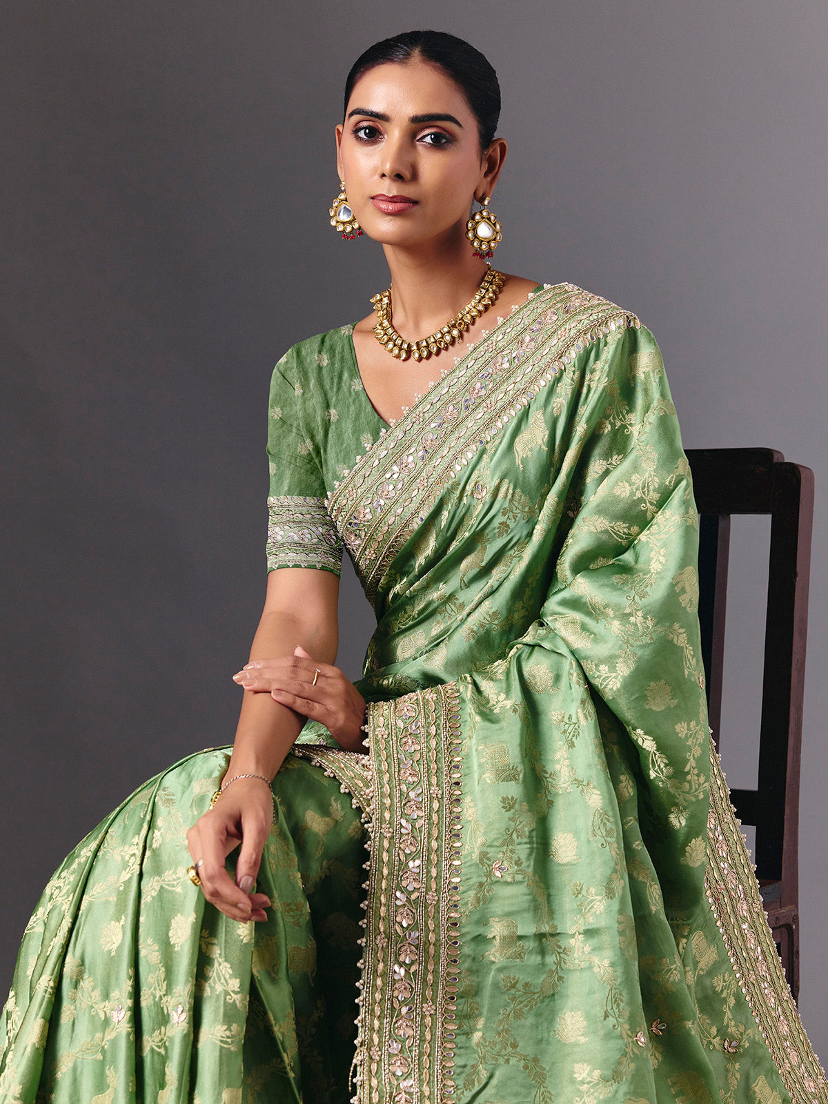 Pista green satin silk saree with ornate animal motif detailing