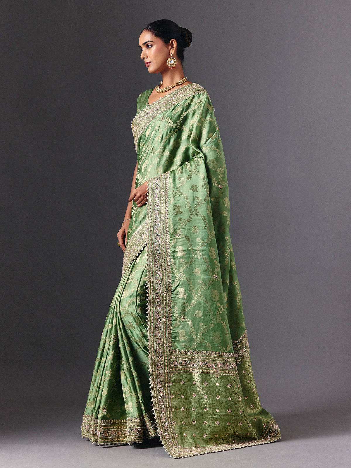 Pista green satin silk saree with ornate animal motif detailing