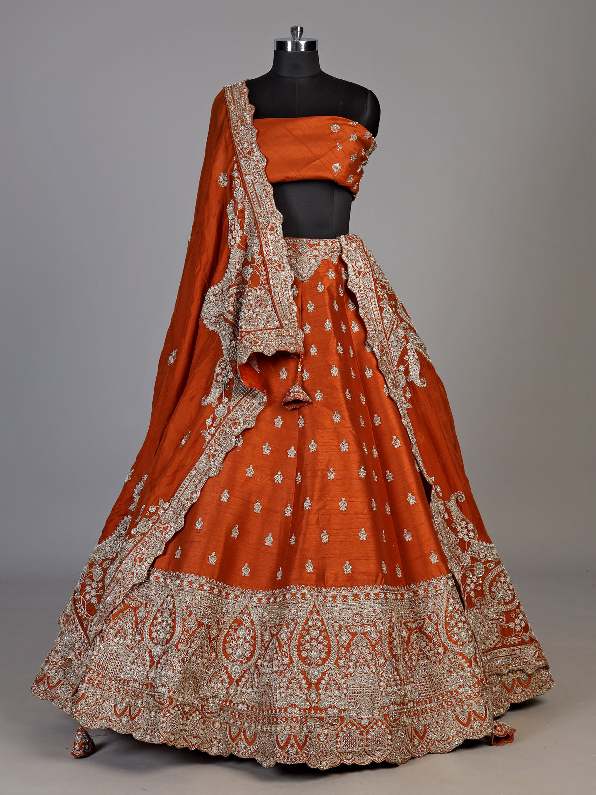 Rust orange raw silk unstitched lehenga choli with ornate butti detailing