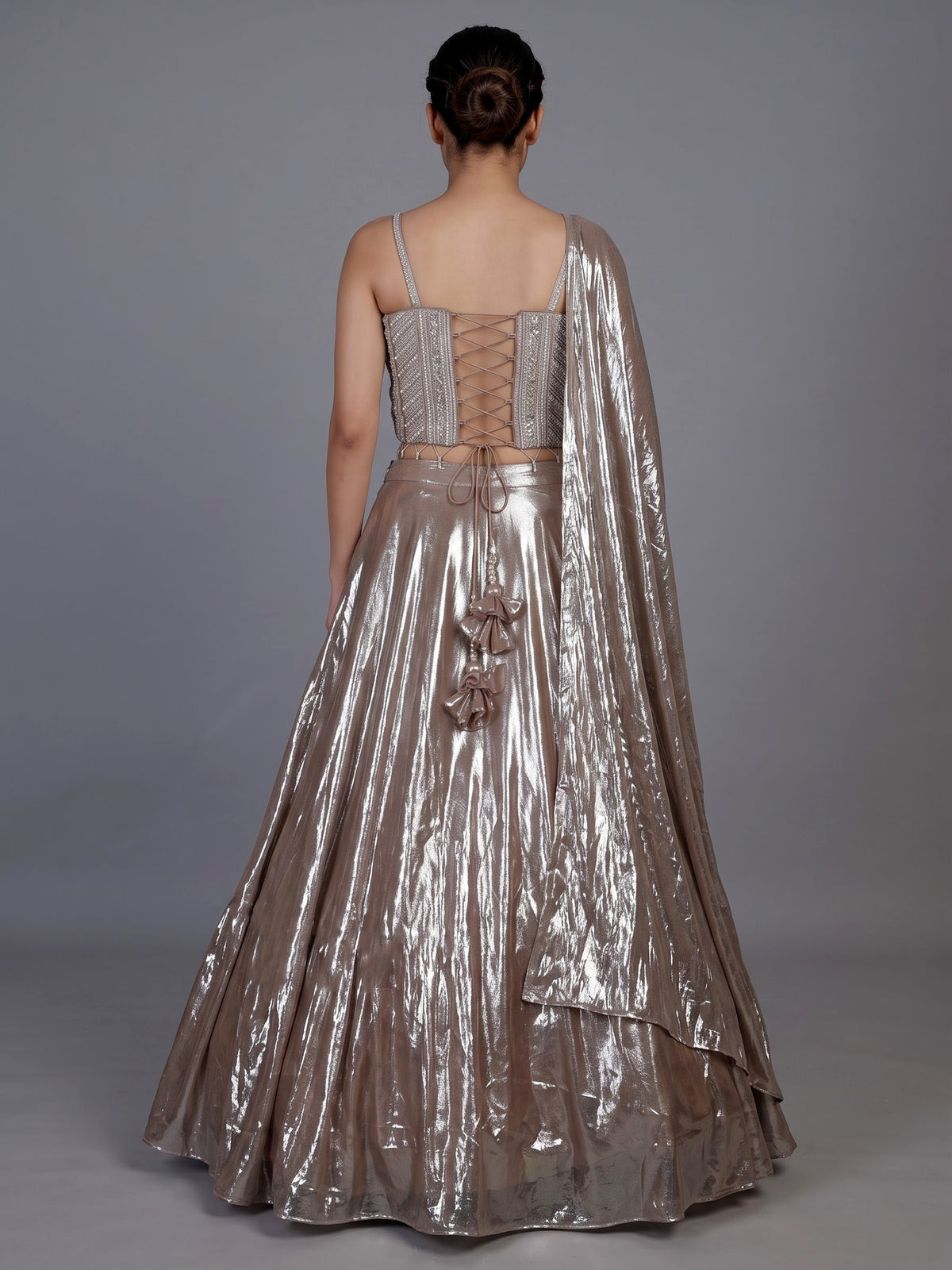 Sophisticated beige shimmer tissue silk lehenga choli with tassel accents