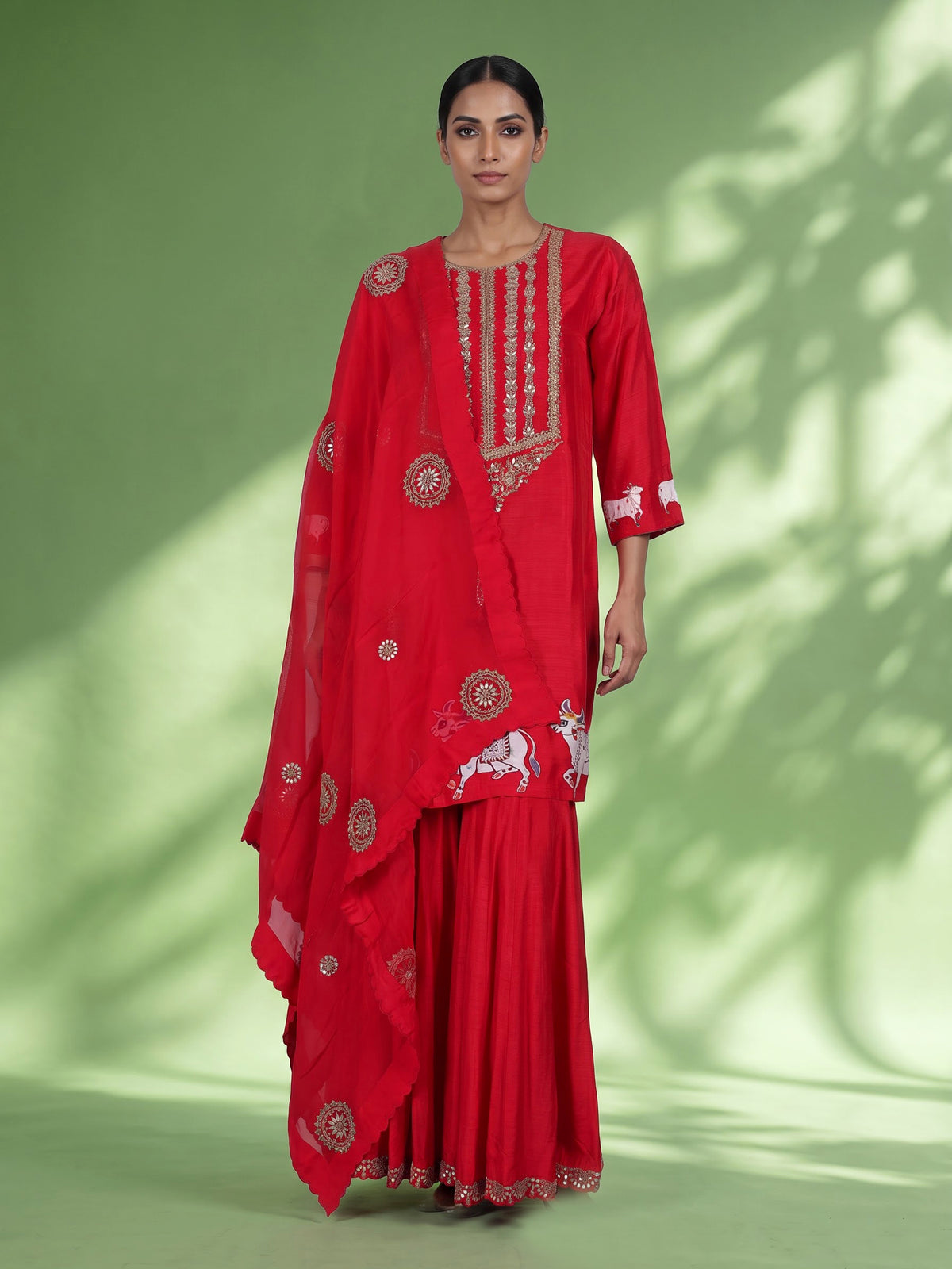 Red silk sharara suit with animal motifs, zardosi and gota detailing
