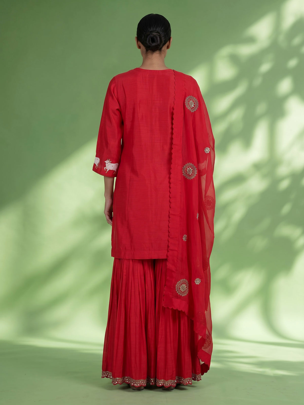 Red silk sharara suit with animal motifs, zardosi and gota detailing