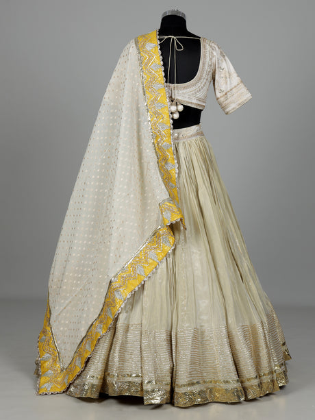 Beige silk lehenga choli with traditional aabla and gota work