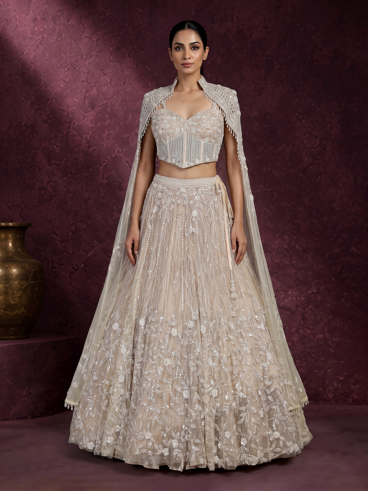Beige net designer lehenga choli with heavy embellished cape shrug
