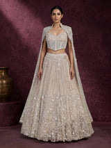 Beige net designer lehenga choli with heavy embellished cape shrug
